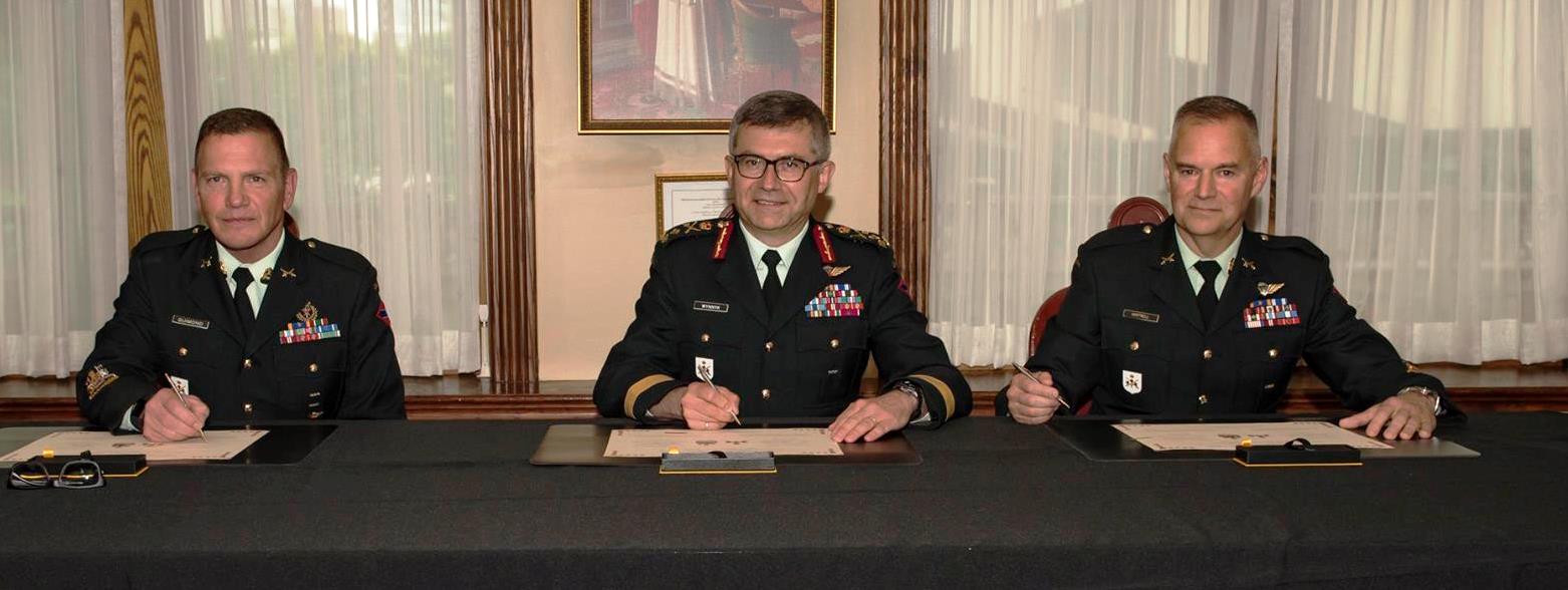 LGen Paul Wynnyk, Commander of the Canadian Army, CWO Alain Guimond, outgoing Army Sergeant Major, (Left) and CWO Stuart Hartnell, incoming Army Sergeant Major (Right) sign the Change of Appointment scroll.