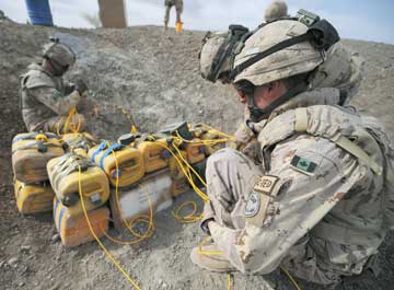 Canadian combat engineers rig improvised explosive devices with C-4 and a detonation cord to dispose of them.