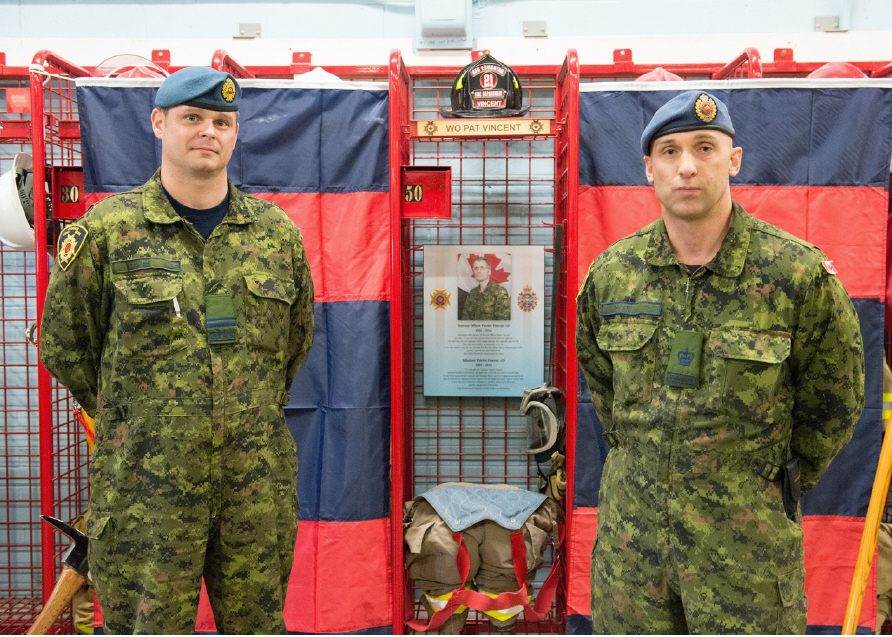 Lt Jean-Guy Mayer, the Edmonton Garrison Fire Chief, and WO Ryan Vincent during the dedication of a Fire Fighter bunker gear stall to honour the late WO Patrice Vincent // Le Lt Jean-Guy Mayer, le chef des pompiers de la garnison d’Edmonton et l’Adj Ryan Vincent pendant l’inauguration d’un casier pour la tenue de feu des pompiers en hommage au regretté Adj Patrice Vincent</p>