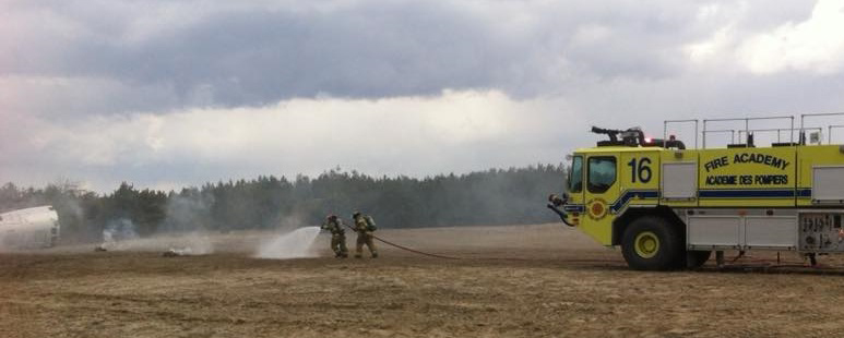 During the QL6 Supervisor Course, Lieutenant Jenson Gilby, on the nozzle, and Sergeant Matthew Mitton, on the hose, extinguish spot fires after a simulated aircraft crash at the Canadian Forces Fire and Nuclear, Biological and Chemical Academy at CFB Borden, Ontario. PHOTO: Courtesy of Lieutenant Jenson Gilby