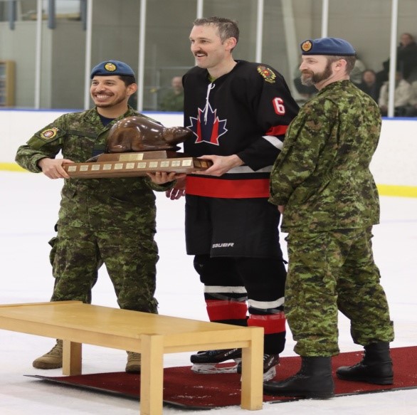 LCol Michael Ulloa CO RP Ops and his SM Drew Scott present the “Beaver” trophy to Jordan Semeschuk, Head of DCC, captain of the winning Bandits.