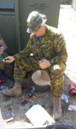 Sgt Humber, ED Tech, installing the connectors on the electrical cables // Sgt Humber, Tech ED, installe les connecteurs aux câbles électriques