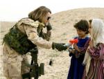 A Canadian soldier gives an Izzy doll to girls in Afghanistan // Une soldat canadienne donne une poupée Izzy à des filles en Afghanistan.