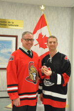 BGen Derek Basinger hands off the “Director’s Collar Dog” after completing the handover of responsibilities to Col Kyle Solomon during the quasi-official ceremony held in some random hallway in the basement of NDHQ. Photo taken by the Deputy Minister’s Office