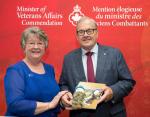 Shirley O'Connell presents an Izzy Doll to Minister Lawrence MacAuley