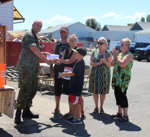 Maj Fenton handing Comox chapter contributions to Marc, Kaitha and their family
